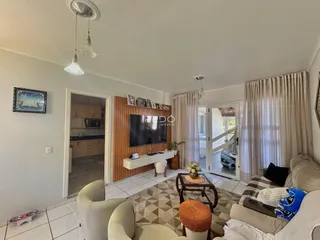 Sala de estar com vista para a cozinha em um imóvel no Brasil.