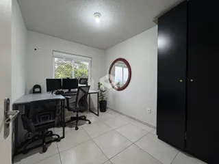 Uma sala de escritório com mesa e armário no interior da residência.