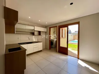 Vista de uma cozinha moderna com armários brancos e piso de cerâmica.