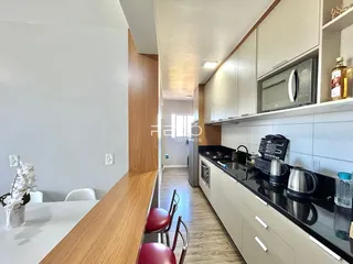Vista da cozinha moderna com armários e bancadas escuras em Lajeado.