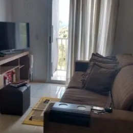 Sala de estar com sofá e vista para o exterior.