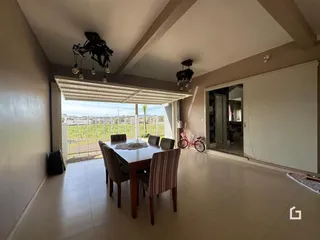 Vista interna de uma sala de jantar com vista para o exterior.