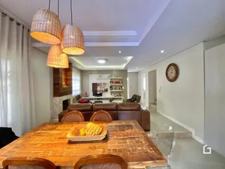 Uma mesa de madeira com cadeiras está no ambiente interno da propriedade.