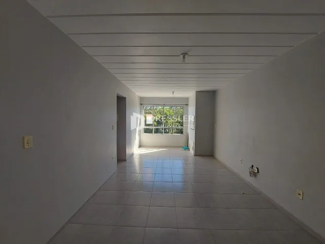 Corredor interno com piso de cerâmica e paredes brancas.