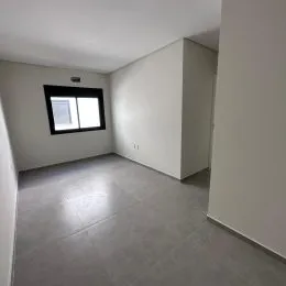 Sala de estar com piso claro e janela visível na parede.