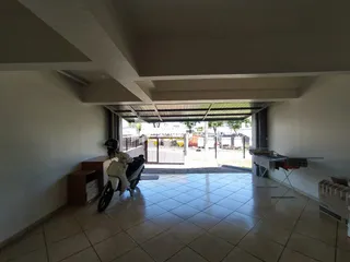 Interior de uma sala com piso de cerâmica e uma porta de acesso ao exterior.