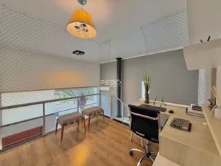 Ambiente interno de sala com piso de madeira e vista para a varanda.