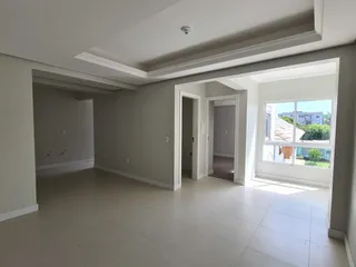 Sala de estar ampla com piso claro e paredes neutras.