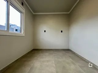 Vista interna de um cômodo com piso de cerâmica e janela.