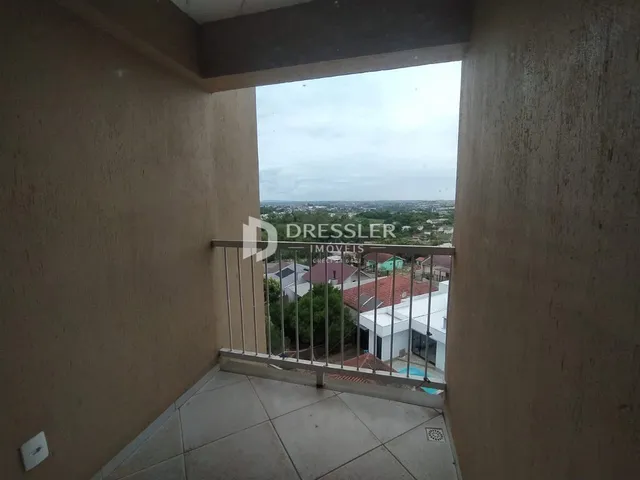 Vista de um ambiente interno com acesso a uma varanda com vista para a paisagem.