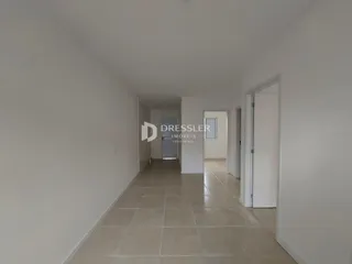 Corredor interno de uma residência com piso de cerâmica claro.