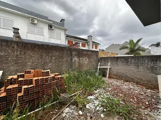 Fachada de uma propriedade com muro e materiais de construção no primeiro plano.