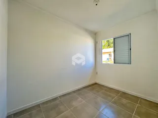 Ambiente interno de uma sala com piso de cerâmica e parede branca.