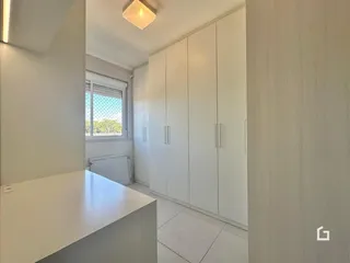 Vista interna de um corredor com armários embutidos e janela.