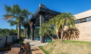 Fachada de uma residência com palmeiras e área externa.