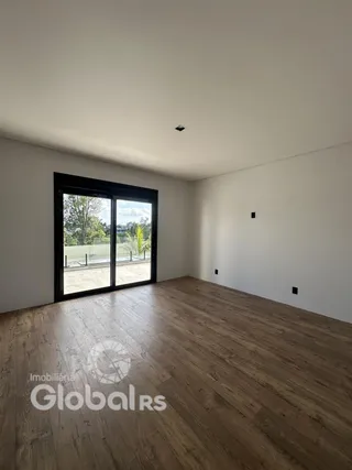 Sala de estar com piso de madeira e portas de vidro grandes.