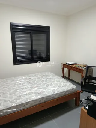 Quarto com cama e janela em uma residência.