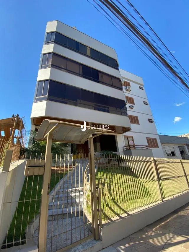 Fachada de um prédio residencial em Lajeado, Brasil, com cerca e paisagismo.