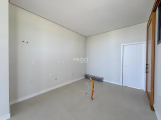 Ambiente interno amplo com paredes brancas e piso claro.