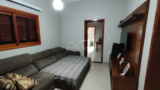 Foto de uma sala de estar com sofá e estante de madeira em um apartamento.