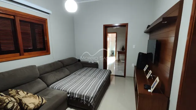 Foto de uma sala de estar com sofá e estante de madeira em um apartamento.