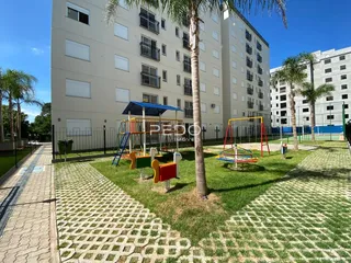 Foto da fachada de um prédio residencial com área de lazer externa.