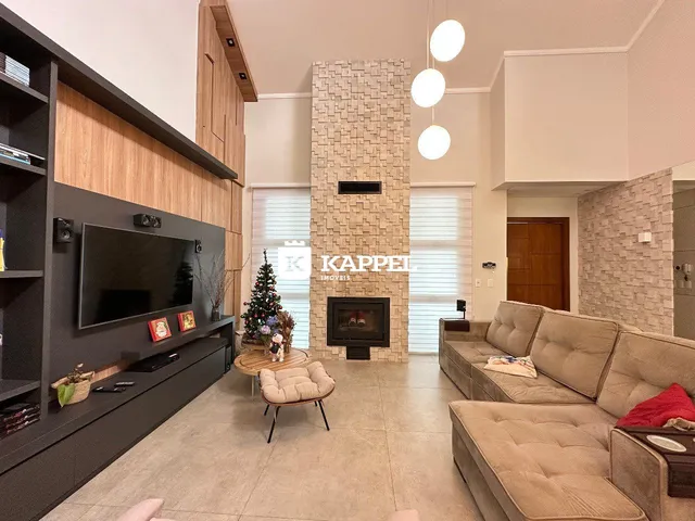 Sala de estar ampla com sofá, televisão e lareira em ambiente moderno.