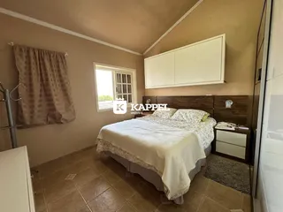 Quarto com cama e armário branco em um imóvel.
