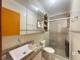 Foto de um banheiro com azulejos brancos e bancada de granito.