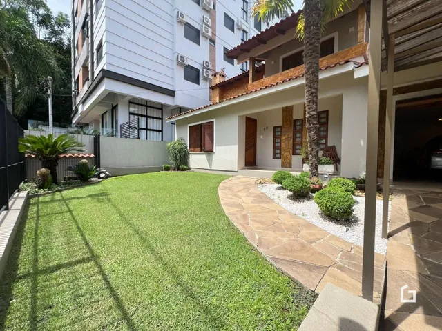Vista da fachada de uma residência com jardim e área externa em Lajeado.