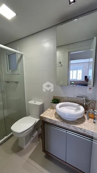 Foto de um banheiro com revestimento branco e bancada de granito.