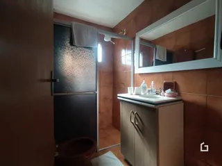 Foto de um banheiro interno com azulejos marrons.