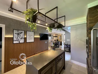 Interior de uma sala de estar moderna com painéis de madeira e arte.