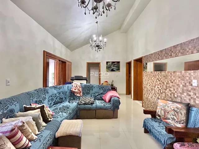 Sala de estar ampla com paredes brancas e sofá azul.