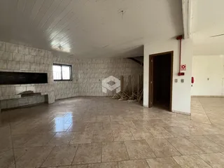 Foto do interior de um espaço amplo com piso e paredes de cerâmica.