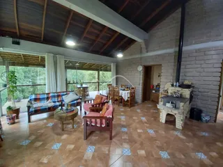 Sala de estar com vista para o exterior e área de churrasco.