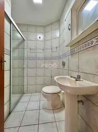 Foto de um banheiro com revestimento de cerâmica e louças sanitárias.