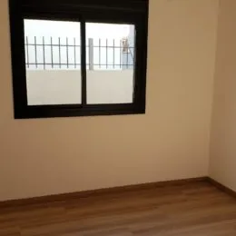Foto de uma janela preta em uma parede de cor bege.