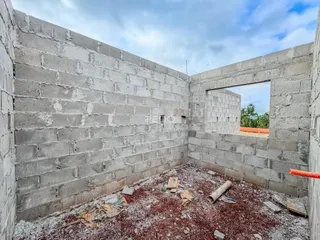 Parede interna de um imóvel em construção com paredes de bloco de concreto.