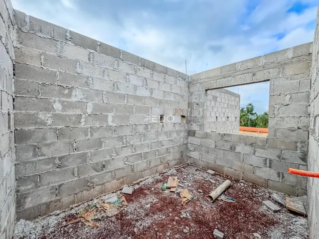 Parede interna de um imóvel em construção com paredes de bloco de concreto.