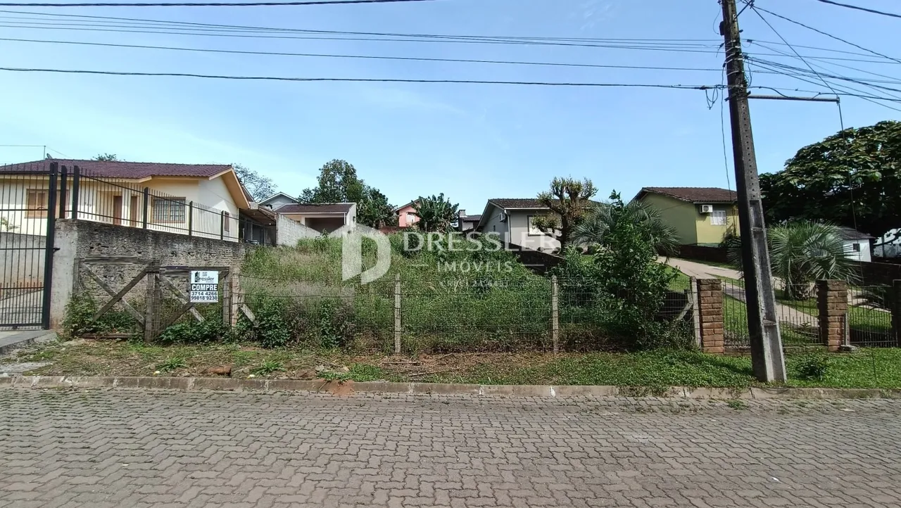 Vista da fachada de casas em Lajeado, Brasil, com cerca e vegetação.