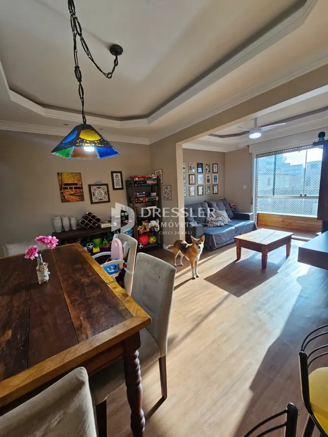 Sala de estar com piso de madeira e grande janela.