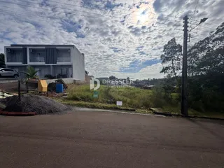 Fachada de uma residência em Lajeado, Brasil, com área de terra e materiais de construção ao redor.