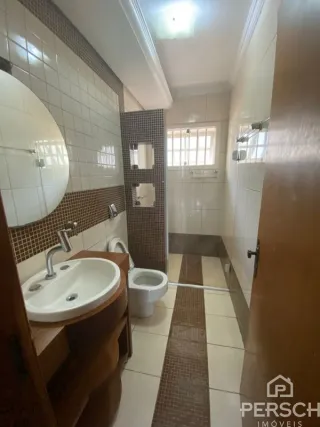 Corredor interno com paredes revestidas e piso claro.