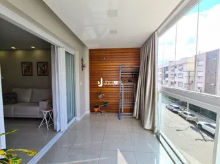 Sala de estar com portas de vidro e parede de madeira em um imóvel no Brasil.