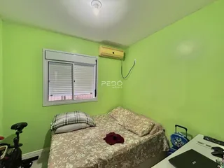 Quarto com cama e janela em uma sala de estar verde.