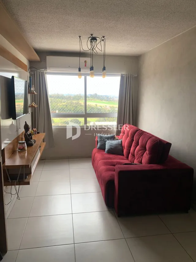 Sala de estar com sofá vermelho e janela.