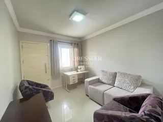 Foto de uma sala de estar interna com sofás claros.