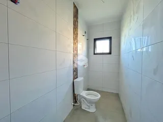 Foto interna de um banheiro com paredes brancas e piso claro.
