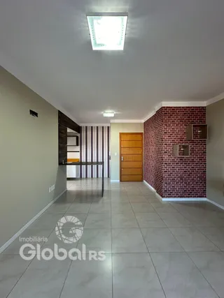 Corredor interno com piso de cerâmica e parede de tijolos vermelhos.